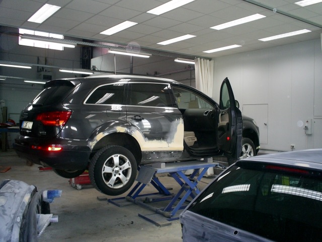 Audi Q7 in de werkplaats met primer op het herstelde achterscherm